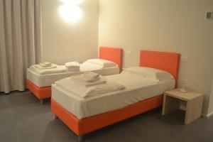 维罗纳StraVagante Hostel & Rooms的两张橙色床位于客房内