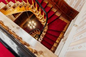 佩尔莱贝格“德意志国王”餐厅酒店的一座铺有红地毯的建筑中的螺旋楼梯