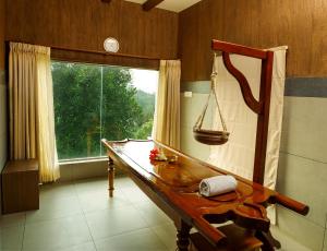 提喀迪Forest Canopy Thekkady的客房设有木桌和窗户。