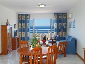 波尔蒂芒达罗沙花园公寓式酒店的客厅配有桌子和蓝色沙发