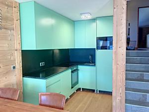 蒙热内夫尔La Durance的厨房配有蓝色橱柜和桌椅