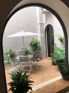 圣胡安The Suites & Vintage Apartment at Casa Of Essence in heart of Old San Juan的拱门,配有桌椅和雨伞
