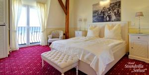 舍恩贝里耶海滩Strandvilla Seelust的卧室配有一张白色大床和一把椅子