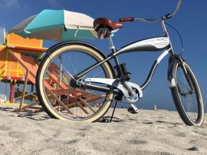 迈阿密海滩世纪酒店的海滩上停放自行车,海滩遮阳伞旁