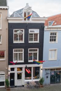 阿姆斯特丹阿米司塔特酒店的一座黑色的建筑,上面挂着五颜六色的风筝