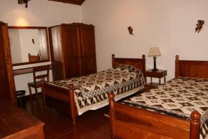 普拉亚达维多利亚Quinta dos Figos "5 Trevos GOLD"的一间卧室配有两张床、一张桌子和一面镜子