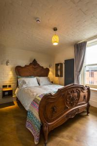 都柏林McGettigan's Townhouse - Olives & Figs Bistro的一间卧室设有一张大型木床和一个窗户。