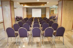 蒙特雷蒙特雷历史旅游酒店的一间会议室,配有紫色椅子和屏幕