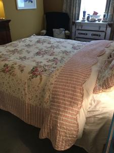 斯旺西Wynberg House Bed & Breakfast的一间卧室配有一张带花卉床罩的床