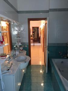 特拉尼B&B DONNA PORZIA的浴室设有2个水槽、浴缸和镜子