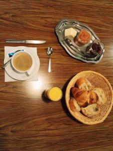Fresne-Saint-MamèsL'Hôtel du Mouton blanc的桌上放着一碗面包和一杯咖啡