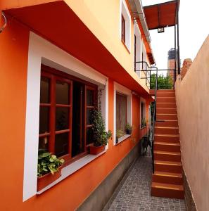 卡法亚特Hopedaje Felisa的一座橙色和白色的建筑,有楼梯和盆栽植物
