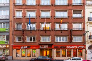 布鲁塞尔健康公寓酒店的前面有旗帜的大型红砖建筑
