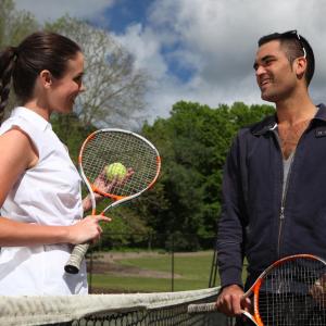 波拉尔佩博斯克雷格本度假酒店的站在网球网上的男人和女人