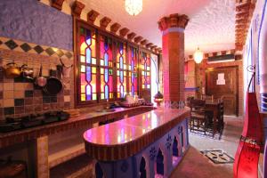 舍夫沙万切斯·阿齐兹公寓式酒店的厨房设有柜台和彩色玻璃窗。