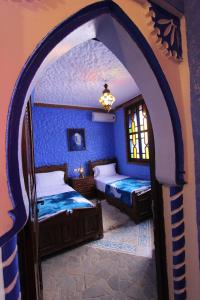 舍夫沙万切斯·阿齐兹公寓式酒店的一间蓝色客房的卧室,配有两张床