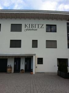 菲伯布伦Haus Kibitz的白色的建筑,上面标有读卡提克兹公寓的标志