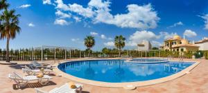 萨拉比塔Residence Club - Es Trenc Beach的一个带椅子和棕榈树的度假村游泳池