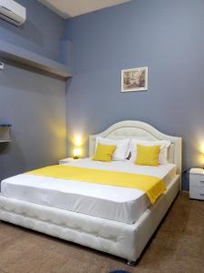 利沃夫Near Rynok Square的卧室配有一张带黄色枕头的大型白色床。