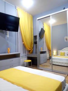 利沃夫Near Rynok Square的一间卧室配有黄色的床和大镜子