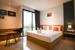 素叻B精品酒店的酒店客房设有床、桌子和窗户。