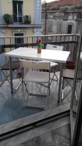 那不勒斯Alexander hostel的阳台上配有白色的桌椅