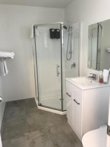 奥克兰午间小憩汽车旅馆的带淋浴和盥洗盆的白色浴室