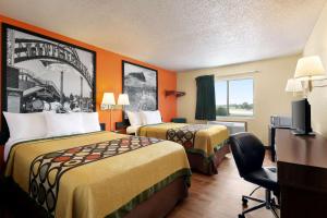韦科韦科大学区速8酒店的酒店客房,配有两张床和椅子