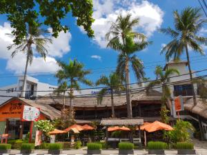 圣吉吉Taman Unique Hotel的一间拥有橘子伞和棕榈树的餐厅