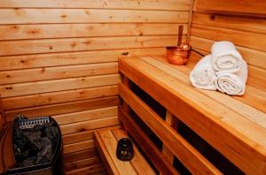 派尔努Embrace Hotel & Apartments的木制平台上的带毛巾的桑拿浴室