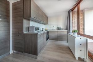 坎布里尔斯Agaró Cambrils Apartments的一间带木制橱柜和微波炉的厨房
