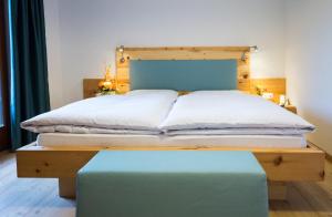 Riobianco菲尔德兰酒店的一间卧室配有一张带木制床头板和蓝色长凳的床。
