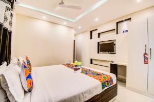 班加罗尔FabHotel Corporate Crown Koramangala的一间卧室配有一张床和电视