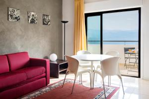 墨西拿安诺齐亚塔住宿酒店的客厅配有红色的沙发、桌子和椅子