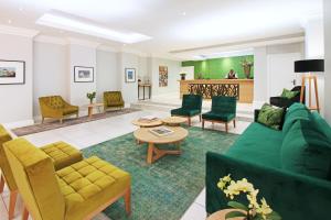 开普敦Hollow on the Square City Hotel的客厅配有绿色沙发和椅子