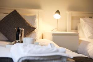 佩斯利Baron View Apartment的酒店客房设有一张带咖啡壶和杯子的床。