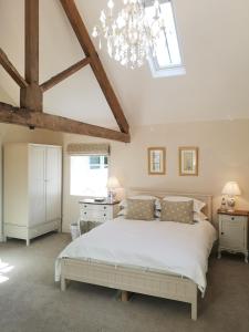 MantonCleatham Hall的卧室配有一张白色的大床和天窗。