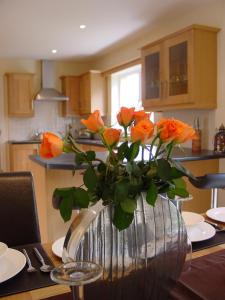 肯梅尔Ardmullen的厨房里桌子上有一个橘色玫瑰花花花瓶