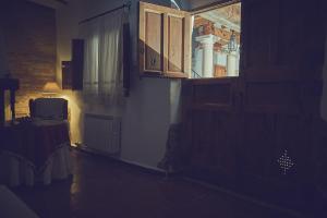 莱图尔Casa rural rincón de Letur的一间黑暗的房间,设有窗户和一张带台灯的桌子