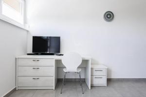 扎达尔时尚中心公寓酒店的一张带电视和白色椅子的白色书桌
