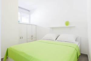 扎达尔时尚中心公寓酒店的白色卧室设有一张带窗户的绿色床
