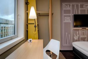 明斯特Ibis Münster City的客房设有桌子、椅子和窗户。