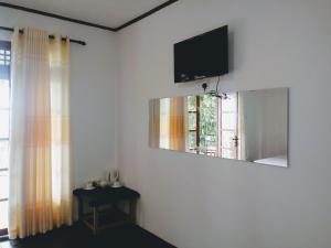 埃拉Okeed Ella的一间墙上配有电视的房间和窗户