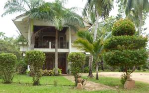 拜蒂克洛里维埃拉度假酒店的前面有棕榈树的房子