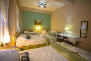 科潘省圣罗莎Hotel San Jorge的酒店客房设有四张床、一张桌子和灯具。