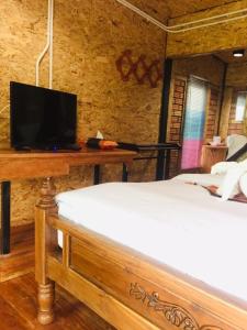 班柯木慕客塔马林德度假村的一间卧室配有一张床和一张桌子上的电视