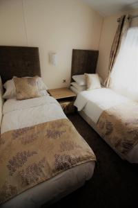 切达Bucklegrove Holiday Park的一间卧室设有两张床和窗户。