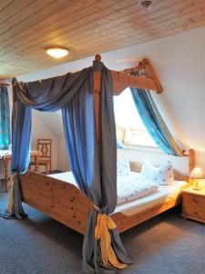 阿尔戈伊地区伊斯尼兰德盖斯霍夫扎姆施沃森格莱特酒店的一间卧室配有一张木床和天篷