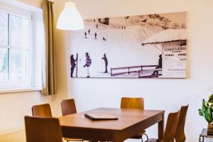卡普伦艾尔文燃涛高山度假酒店的一间用餐室,配有一张桌子和一张墙上的照片