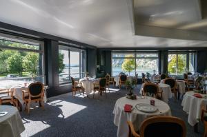 楠蒂阿码头餐厅酒店的用餐室设有桌椅和窗户。